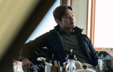어두운 사무실 소파에 앉아 있는 남성